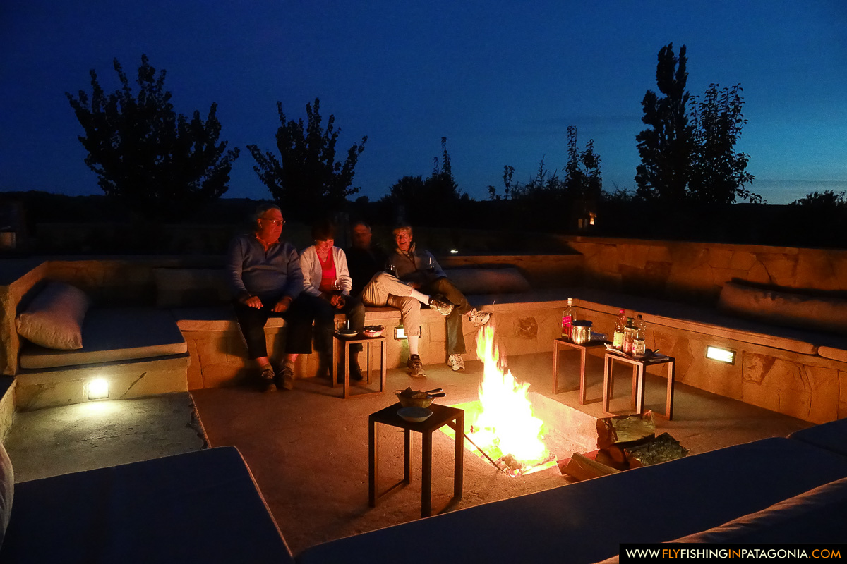 guests gathered around the outdoor fire pit at dusk at Limay River Lodge