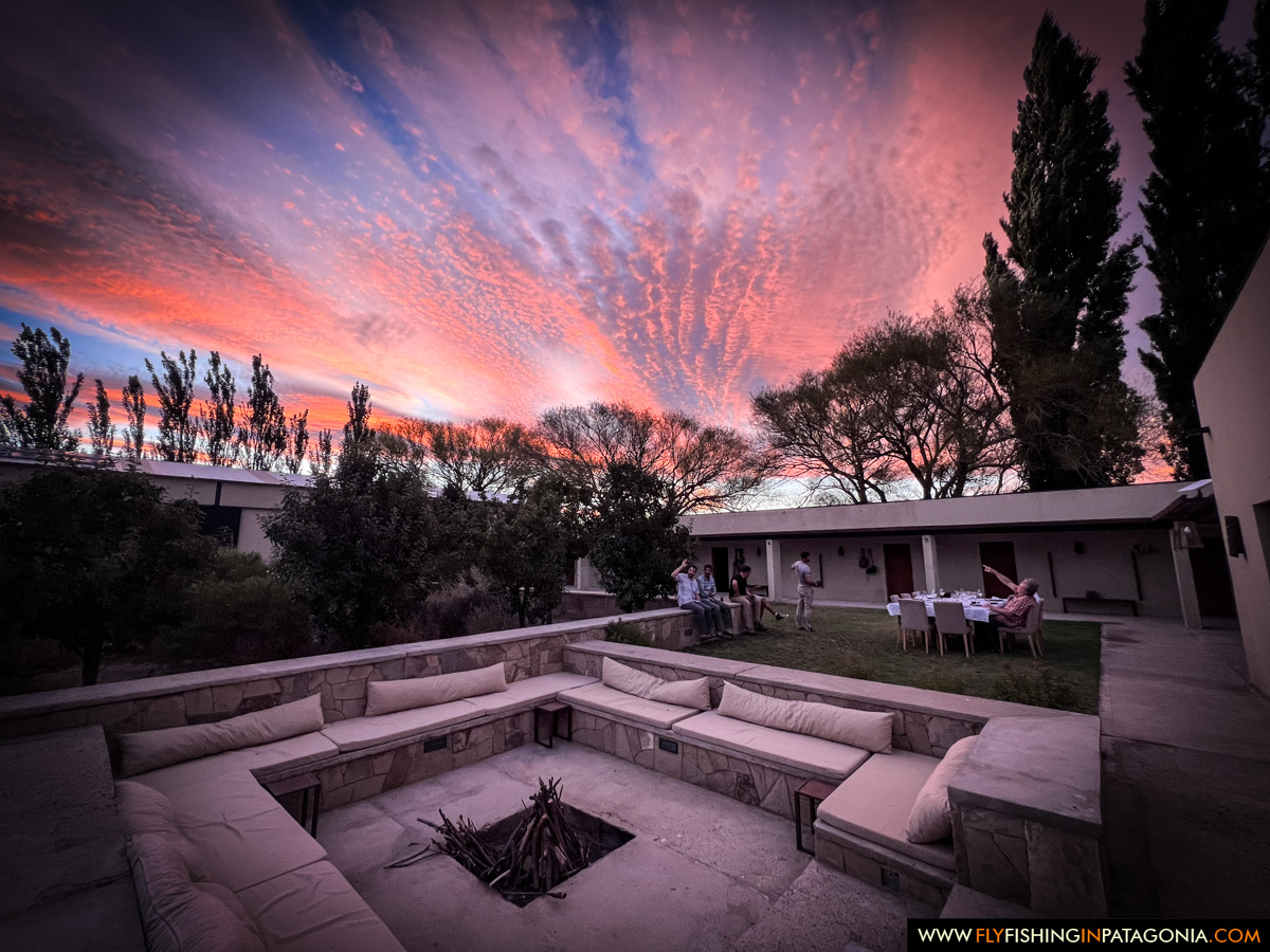 sunset over the fire pit and dining terrace at Limay River Lodge