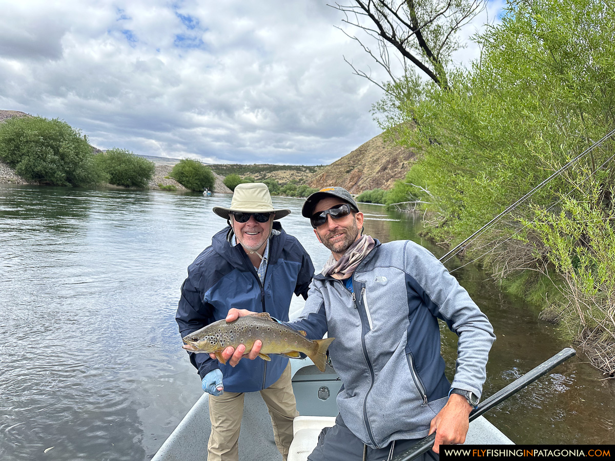 Angler and guide holding a brown trout on the Alumine River