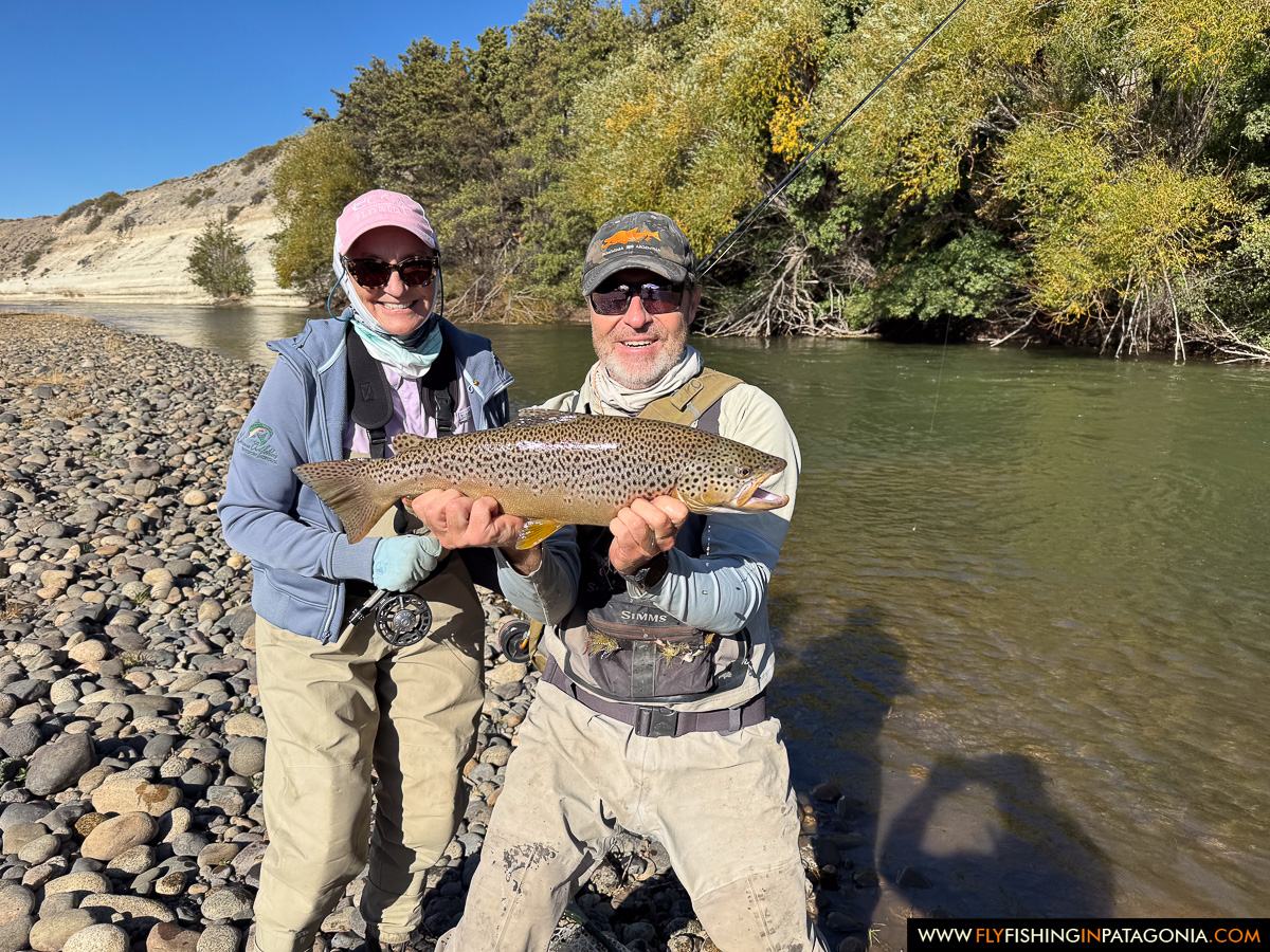Two anglers holding a large brown trout beside the Collon Cura River