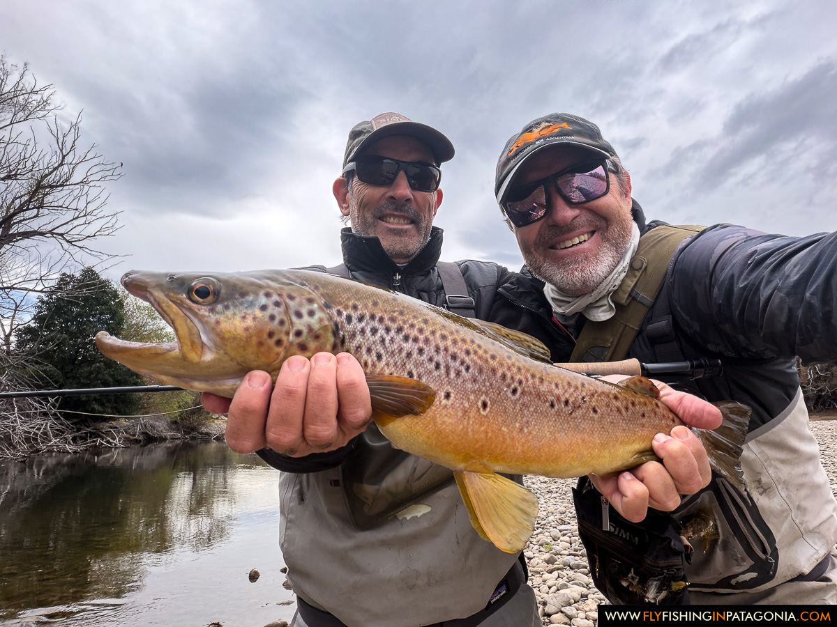 Two anglers presenting a brown trout from the Collon Cura River