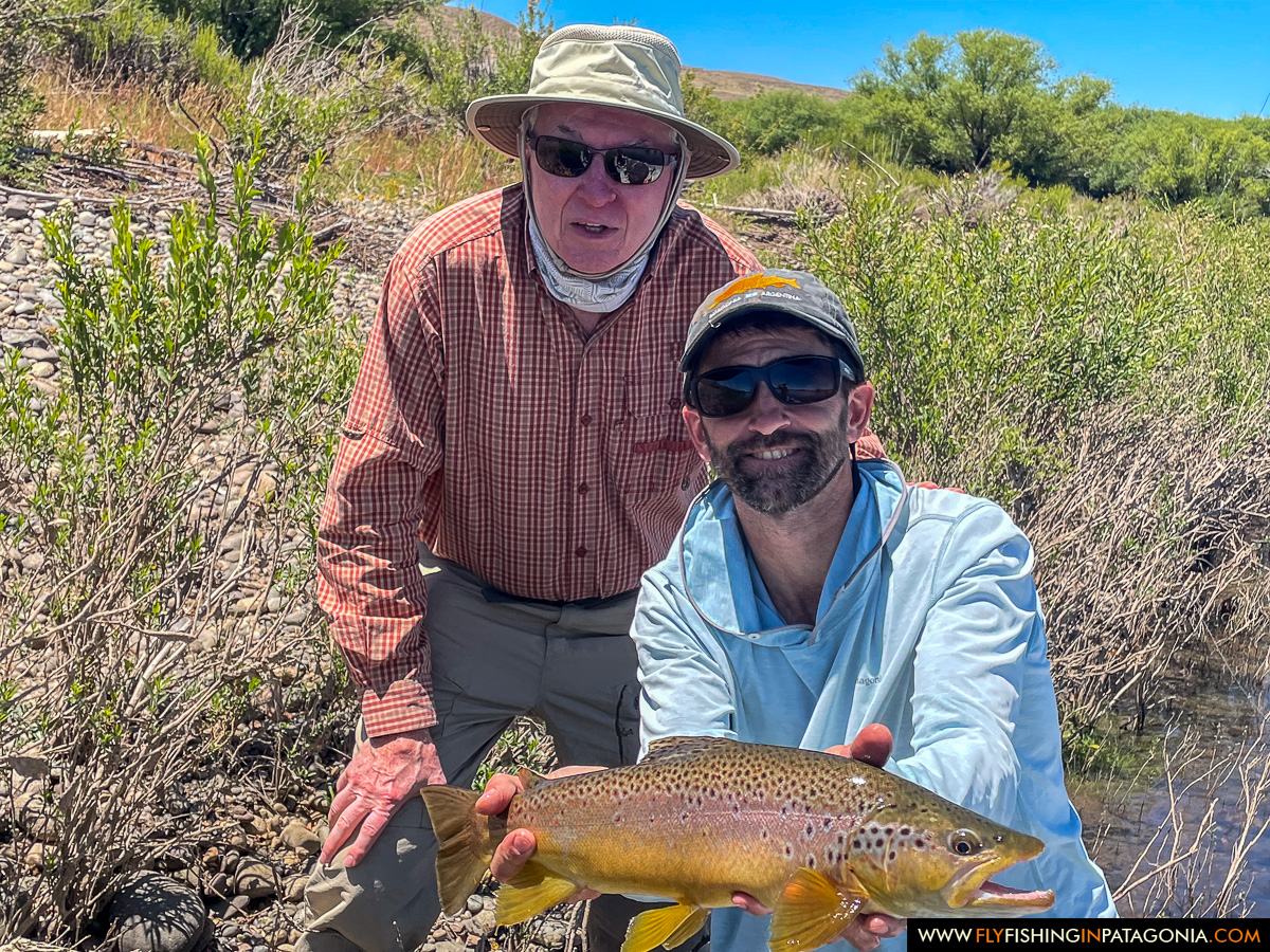 Guide and angler holding a brown trout beside the Collon Cura River