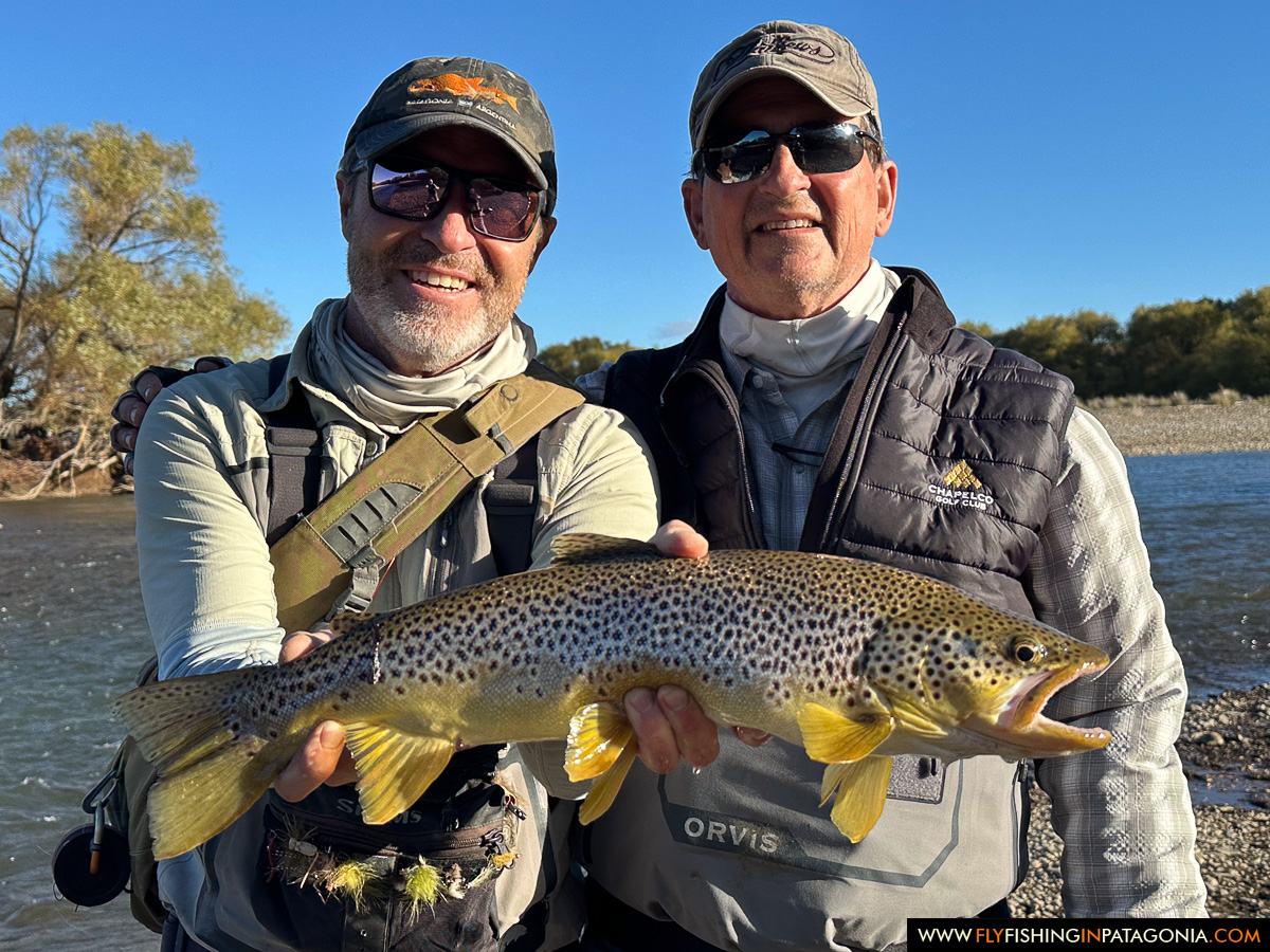 Two anglers presenting a brown trout beside the Collon Cura River