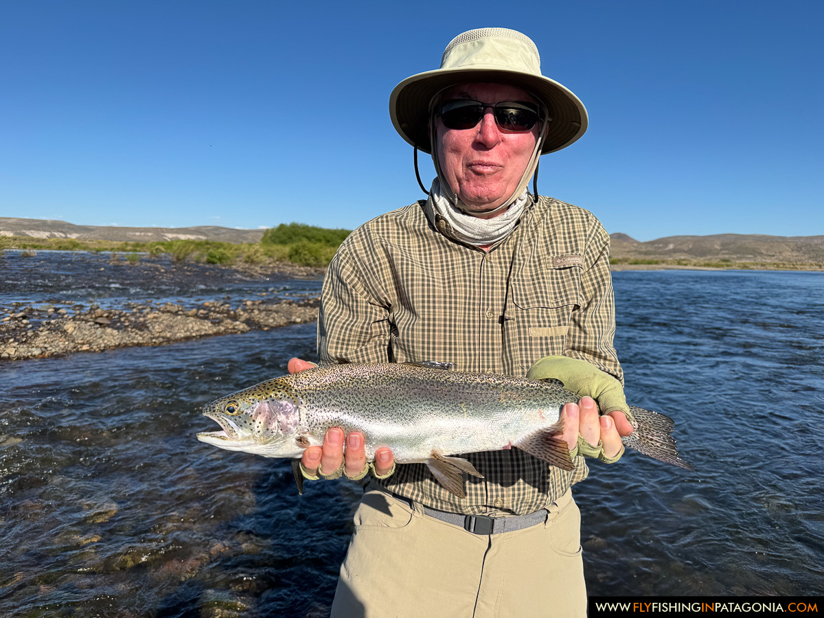 Angler holding a rainbow trout beside the Collon Cura River