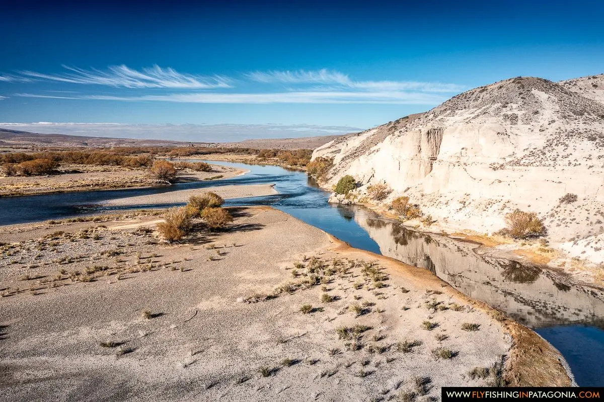 Aerial view of the Collon Cura River flowing beneath pale Patagonian cliffs