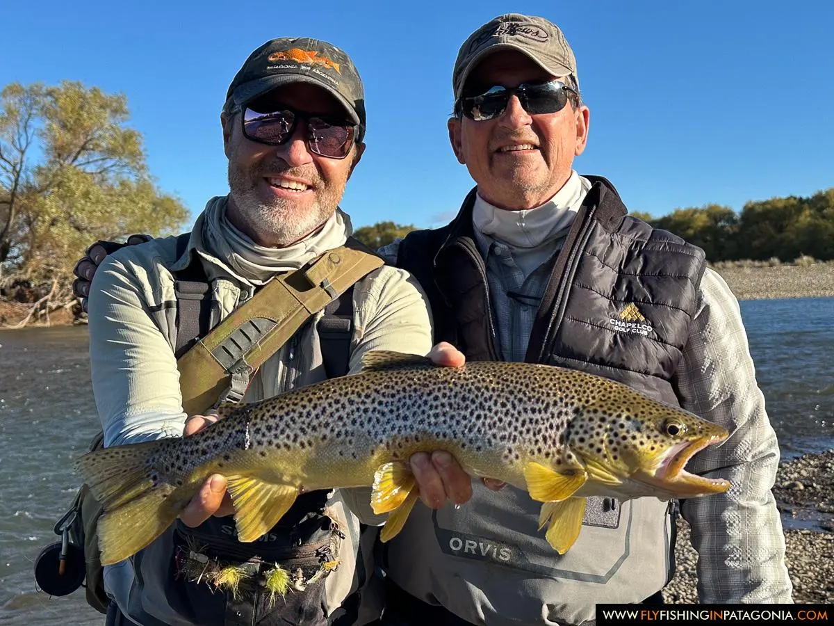 Two anglers presenting a brown trout beside the Collon Cura River