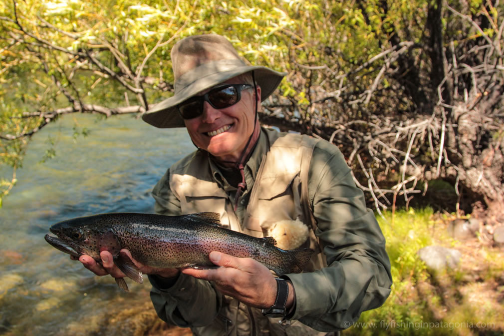 Fly angler holding a rainbow trout beside the Malleo River