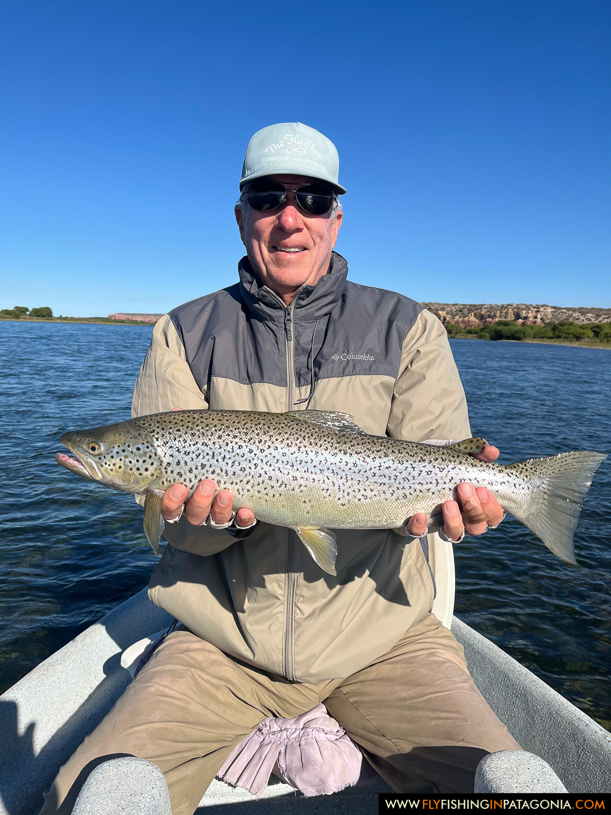 an angler with a nice brown trout landed from the boat on the middle limay river