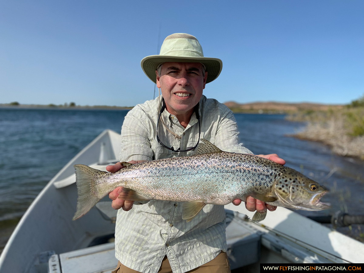 a happy angler with a bright rainbow trout on the middle limay river