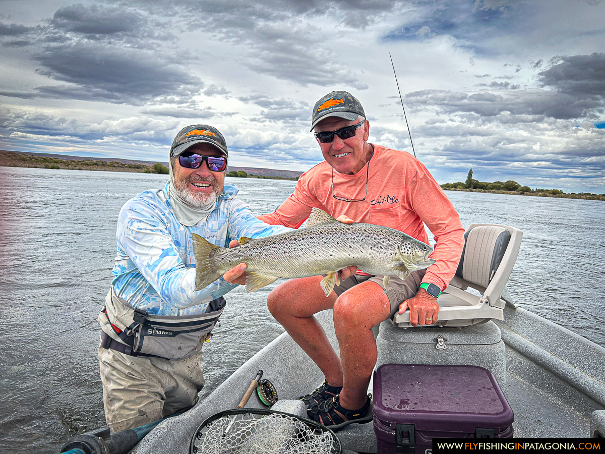 two anglers with a nice trout landed from the boat on the middle limay river