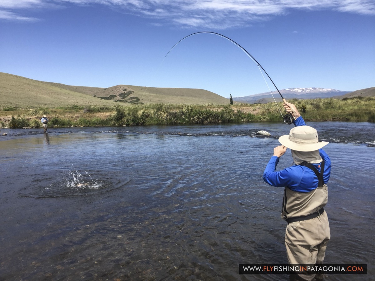 Angler fighting a fish with a deeply bent rod on the Quemquemtreu stream
