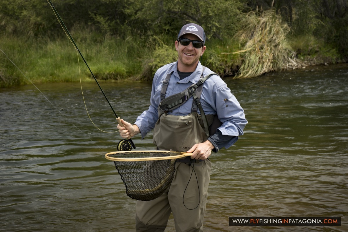 Angler holding a rainbow trout beside the Quemquemtreu stream