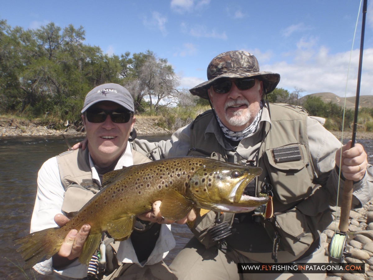 Two anglers holding a brown trout together on the Quemquemtreu stream