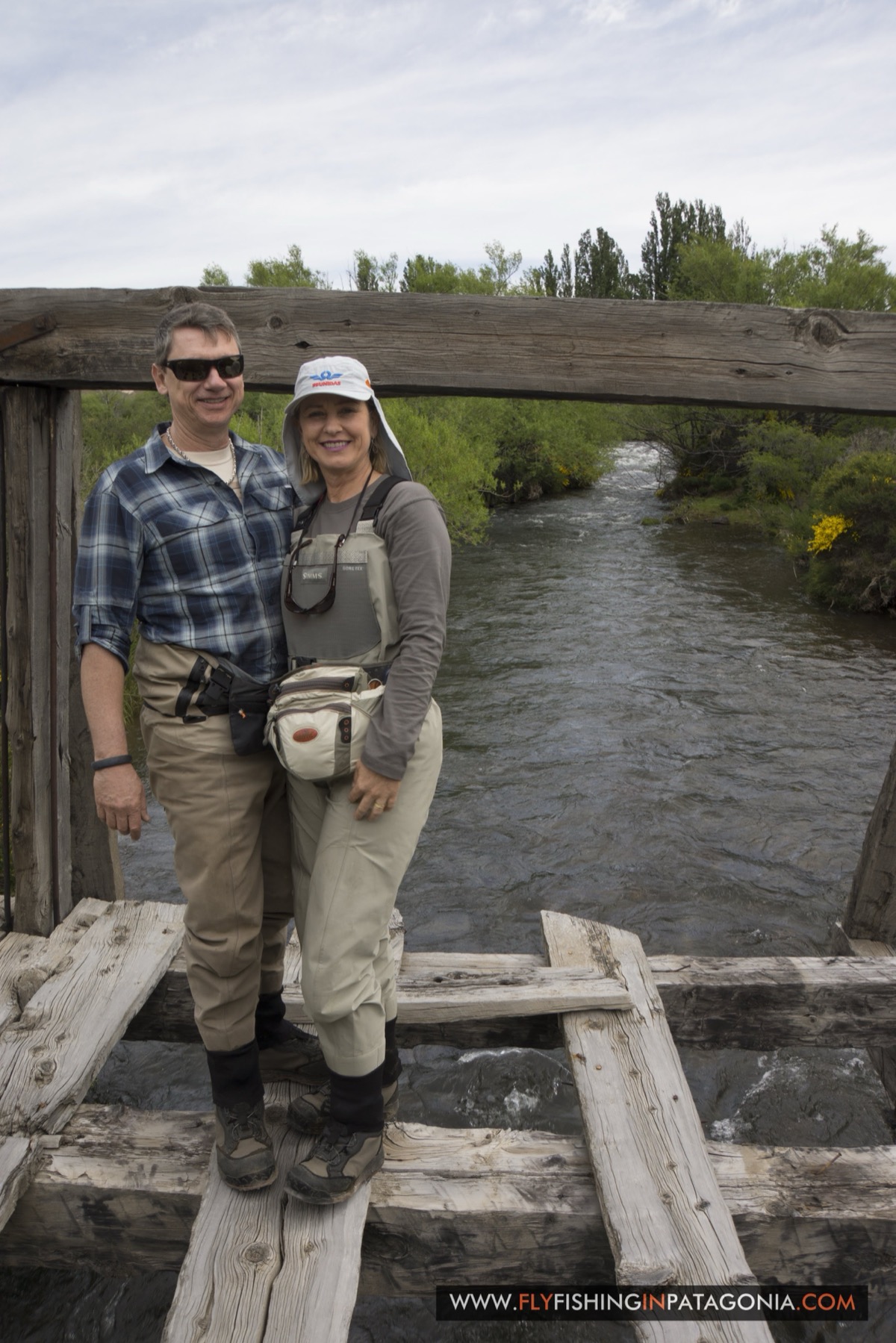 Couple standing on an old wooden footbridge over the Quemquemtreu stream