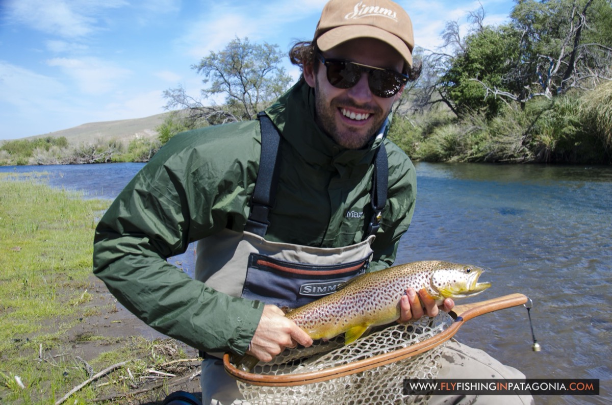 Young angler holding a brown trout beside the Quemquemtreu stream