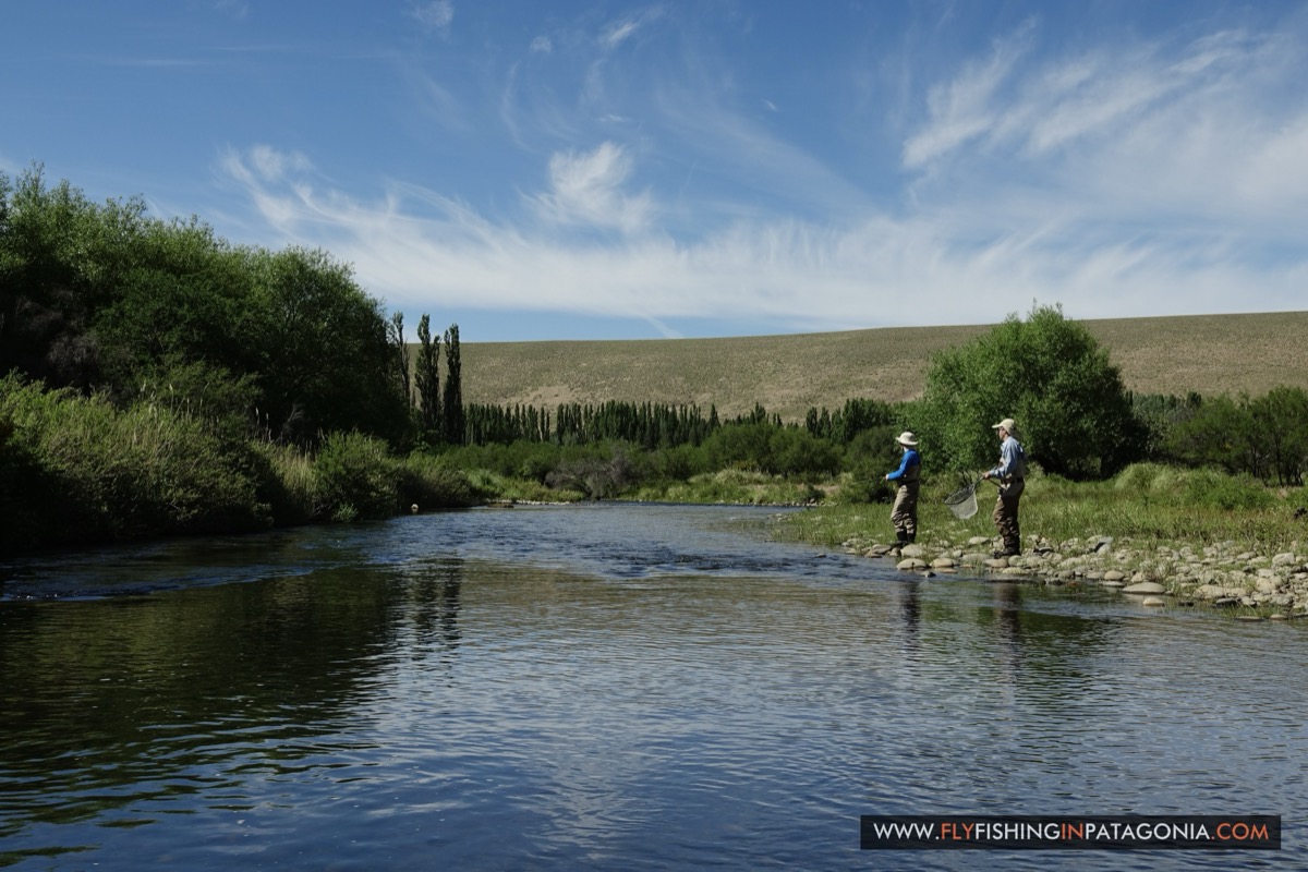 Two anglers fishing a distant bend of the Quemquemtreu stream lined with poplars